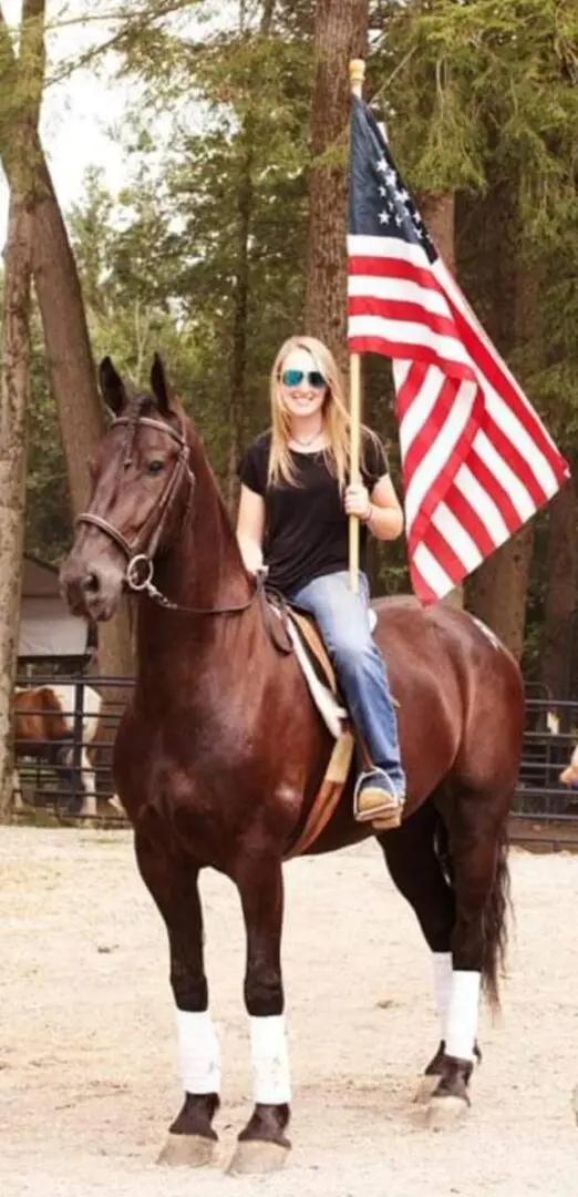 A Woman Sitting on a Horse With a Flag