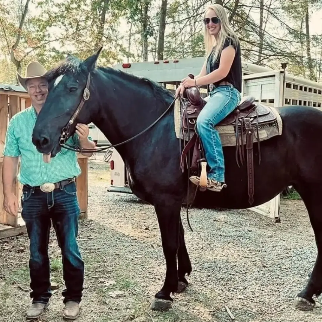 A woman wearing shades and sitting on a horse